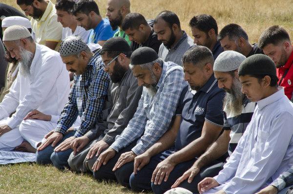 Muslimske menn som kneler og sier sin bønn.