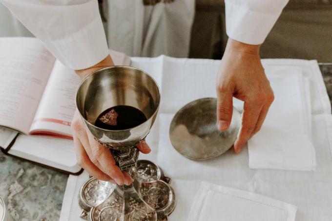 A piece of consecrated host is inside a chalice of wine during the Eucharistic ceremony.