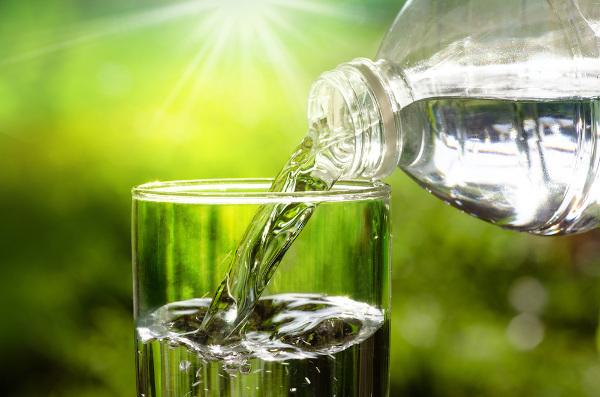 Flytande vatten hälls i ett glas som håller fast behållarens form.