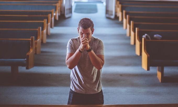 El hombre reza en la iglesia
