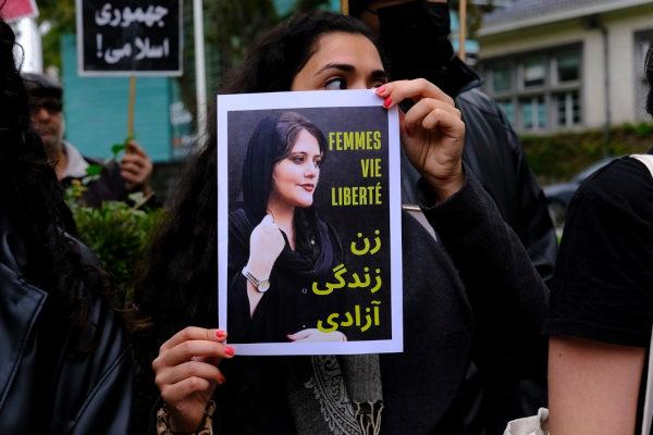 Woman holds photo of Mahsa Amini