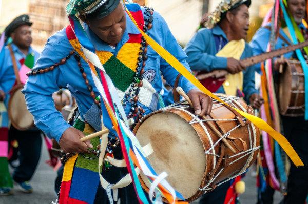 Man playing the drum in a congada parade.