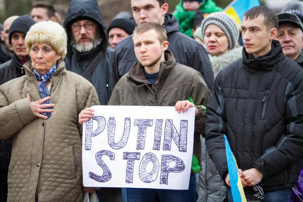 Protest in Ukraine against the 2014 invasion of Crimea, with a young man holding a sign urging Putin to stop. [3]