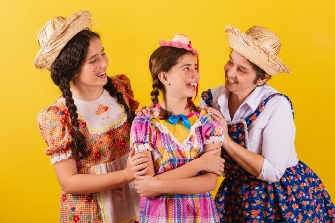 Kvinde og to piger klædt i typisk tøj fra Festa de São João i Brasilien.