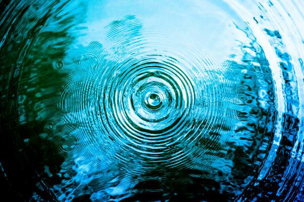 Vagues à la surface d'un lac en raison d'une goutte d'eau tombant.