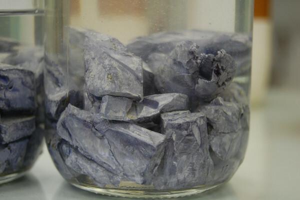 قطع من معدن البوتاسيوم ، معدن قلوي ، يوضع في زيت معدني لمنعه من التفاعل.