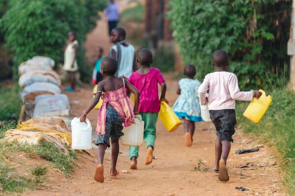 基本的な衛生状態の欠如は、貧困要因の1つです。 写真では、アフリカのウガンダで水を汲んでいる子供たち。