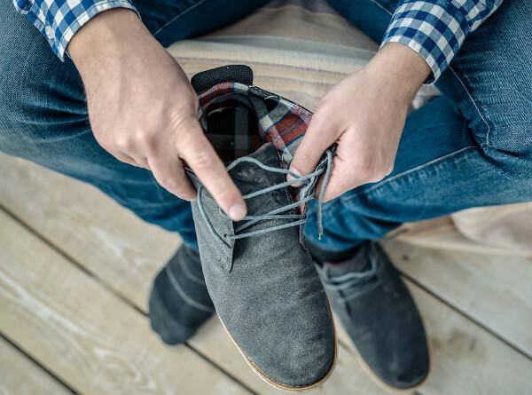 有毒動物との事故を避けるために、靴を履く前に靴を点検する男性。