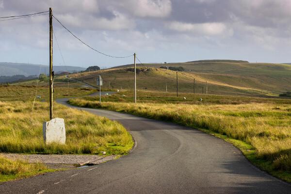 Telegrafstolper på en walisisk landevei i Brecon Beacons, Storbritannia.