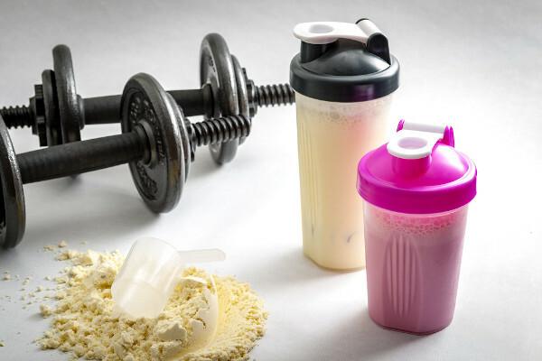 Measuring spoon and albumin powder supplement, two weights and two glasses of skakes.