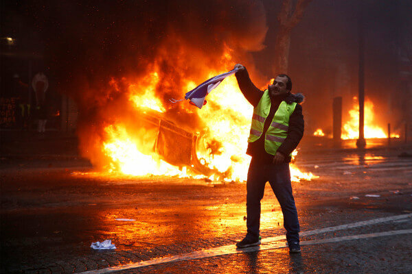 Протестуючі спалюють автомобіль під час протесту. Розбіжності є фундаментальним ознакою демократії.