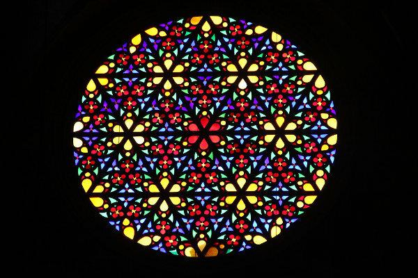 Geam de sticlă, cu o reprezentare a unei mandale, într-o biserică catolică din Mallorca, Spania.