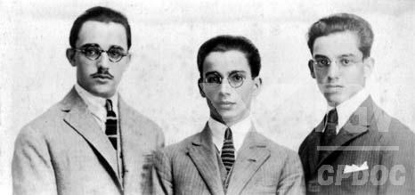 Čiernobiela fotografia Anísia Teixeiru v strede s dvoma priateľmi.