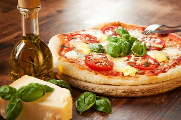 Pizza Margherita di atas meja kayu, salah satu rasa pizza utama dalam sejarah pizza.