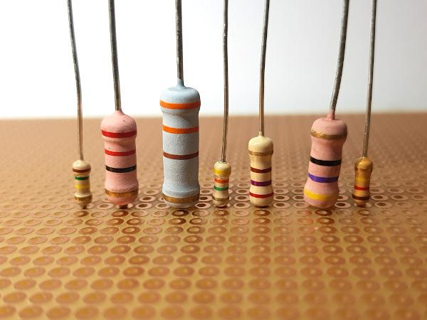 Seven different models of electrical resistor on a wooden table.