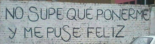 Texto en español escrito en una pared blanca: “No supe qué ponerme y puse Feliz” — Pregunta en español para Enem 2016.